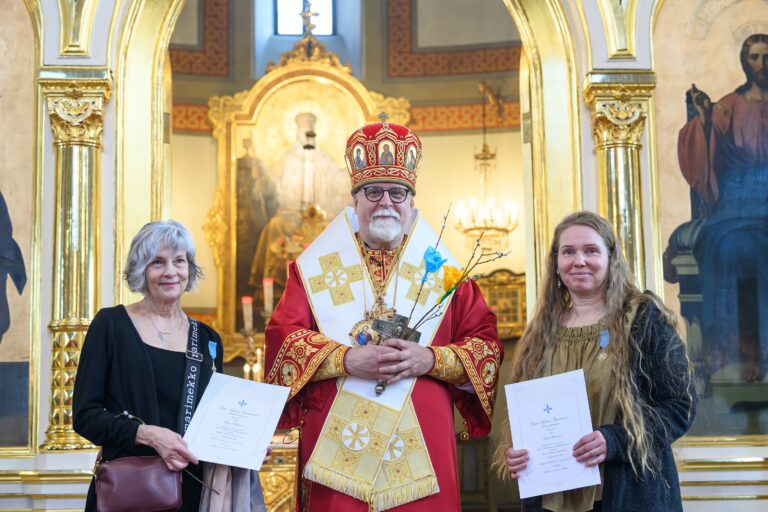 Palkittuja yhteiskuvassa arkkipiispan kanssa.