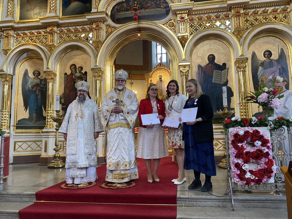 Ansiomerkillä palkitut kanttorit yhteiskuvassa arkkipiispan ja piispa Sergein kanssa.